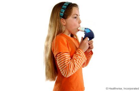 A child breathing out hard into the peak flow meter